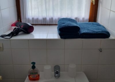 Waschbecken im Bad mit Seife, Föhn und Handtüchern